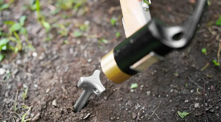 ペグをハンマーで叩いている図